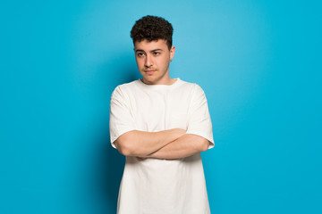 Young man over blue background portrait