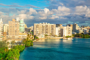 View of Condado area of San Juan Puerto Rico with bay and buildings on a day with clouds and sun. - obrazy, fototapety, plakaty