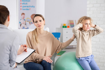 Naughty boy with adhd and sad mother during therapy with psychotherapist - obrazy, fototapety, plakaty