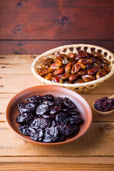 Dried dates and prunes on wooden background. Holy month of Ramadan, concept. Righteous Muslim lifestyle. Starvation. Dried fruits: dates, prunes and raisins on wooden boards