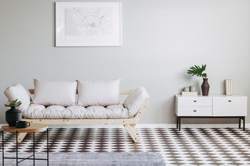 Scandinavian futon in beige living room interior with black and white floor
