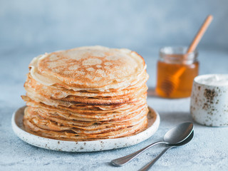 Stack of traditional russian pancakes blini on gray background with copy space. Homemade russian...