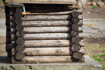 Old well made of wood. Ancient construction technology without nails from tree trunks