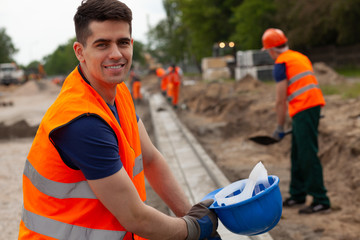 Handsome young road construction worker in orange safety jacket