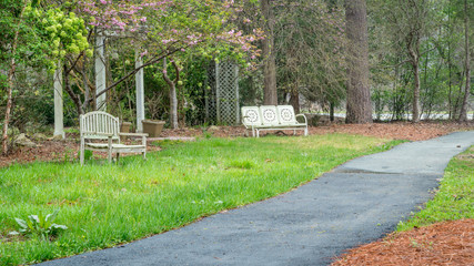 Two wooden benches next to a path