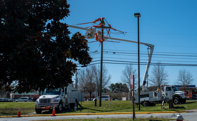men in bucket on extended cherry pickers