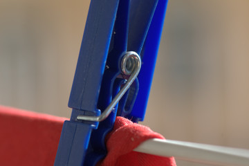 Molletta blu da bucato su maglia rossa