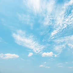 Light white clouds in bright blue sky.