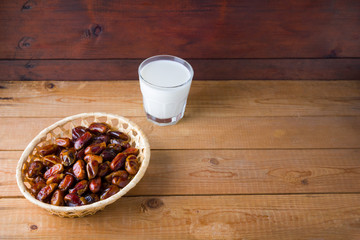 Dried dates and milk on wooden background. Holy month of Ramadan, concept. Righteous Muslim lifestyle. Starvation. Dates in a wooden basket in the style of minimalism. Copy space