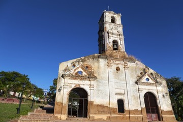 Fototapeta na wymiar Front Facade Wall Exterior of old ruined Spanish church with Bell Tower in Unesco World Heritage Site Trinidad, Cuba