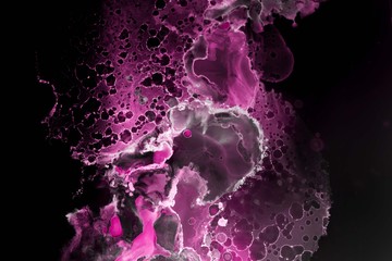 Pink alcohol ink texture with abstract washes and paint stains on the black paper background.	