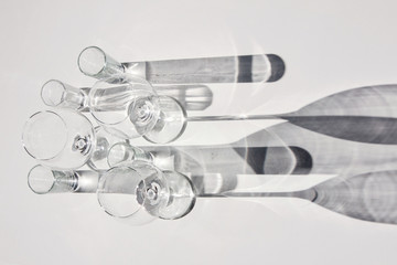 Empty wine glasses and glasses. Abstract shadows, sunlight, white background.