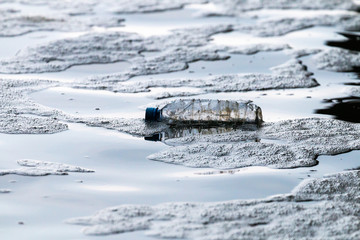 Clear plastic bottle floating in ocean
