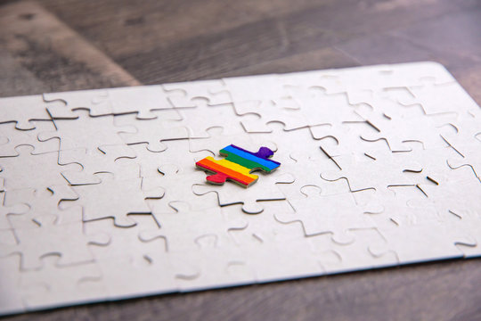 Place of LGBT people in the public structure: puzzle with the coloring of the rainbow flag against a white mosaic, front view