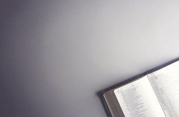 Single Bible Open on a Gray Background