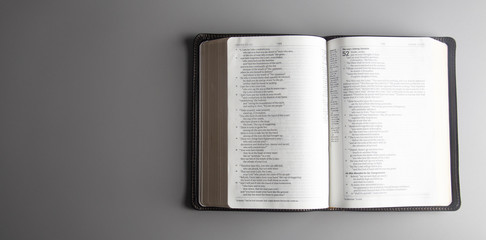 Obraz premium Single Bible Open on a Gray Background