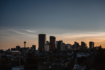 Calgary skyline in the late afternoon with rays from setting sun reflecting off glass buildings.