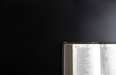 Single Bible Open on a Black Surface