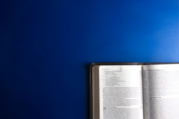 Single Bible Open on an a Blue Background