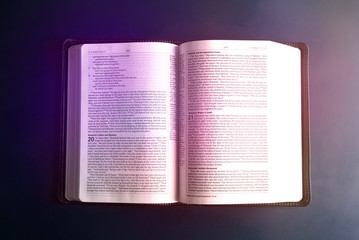 Single Bible Open on an a Blue Background