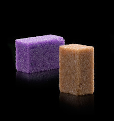 Sugar lumps piled up together against a black background