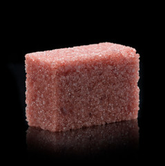 Sugar lumps piled up together against a black background
