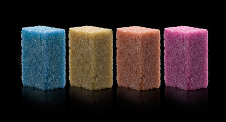 Sugar lumps piled up together against a black background