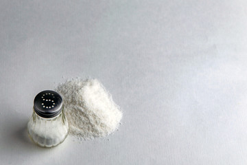 mineral diet: saltcellar with the letter "S" next to a pile of sea salt fluoridated salt on the table