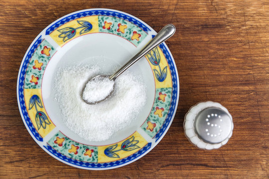 mineral diet: saltcellar with the letter "S" next to a pile of sea fluoride salt in a plate on the table