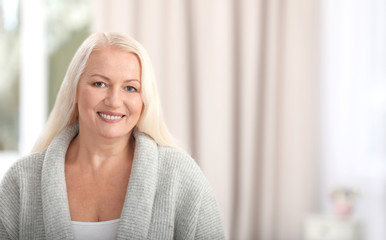 Portrait of beautiful older woman against blurred background with space for text