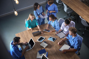 Group of medical students with gadgets in college, top view
