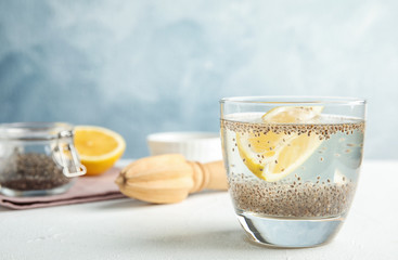 Composition with glass of water and chia seeds on table against color background. Space for text