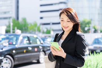 ビジネスウーマン　スマートフォン　駅