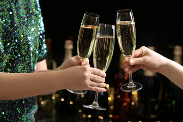 People clinking glasses of champagne on blurred background, closeup