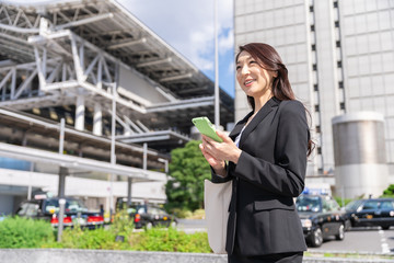 ビジネスウーマン　スマートフォン　駅