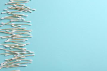 Flat lay composition with cotton swabs and space for text on color background