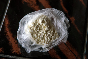 Open package with cocaine on   table, enhanced contrast and clarity