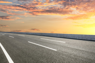 Fototapeta premium Empty asphalt road ground and beautiful sky clouds at sunset