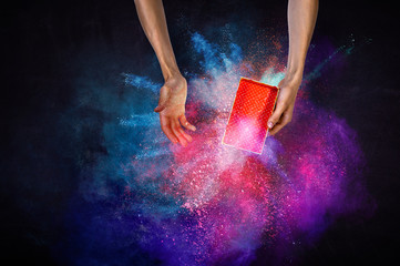 Obraz na płótnie Canvas Man s hands holding a small magic paper box, mixed media