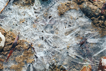 ice crystals pattern over frozen puddle on spring river