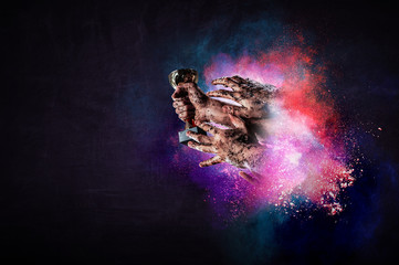 Hands holding champion cup on colourful splashes background. Mixed media