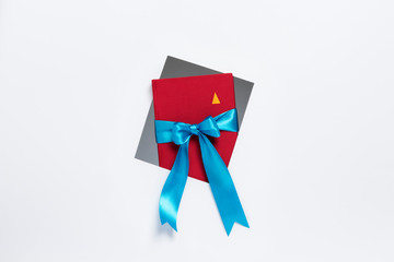 Cuaderno con cinta de regalo saliendo de marco sobre fondo blanco