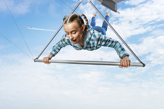 Young woman flying on hang glider. Mixed media