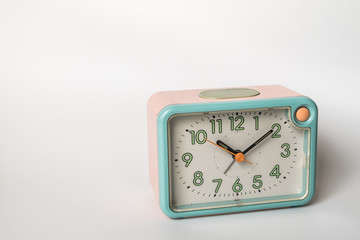 Retro plastic alarm clock pastel color on white background