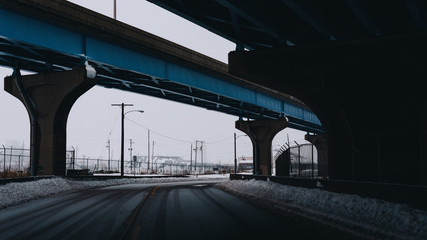 blue snowy urban gritty highway overpass in snowy weather at dusk