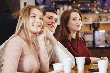 Young friends sitting in cafe.