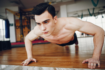 Fototapeta na wymiar Handsome man in a gym. Sportsman in a sportswear. Guy training