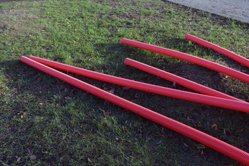 Stack red plastic electricity cable protection pipes