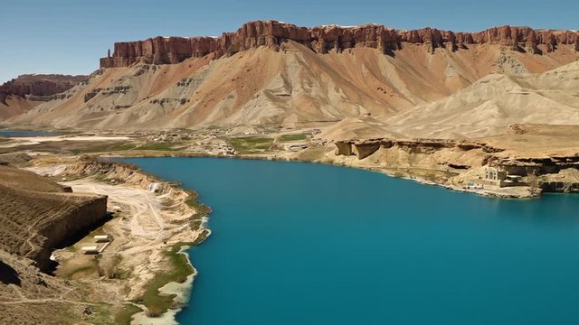 Travertine cliffs surrounded by mountains. Band-e Amir Lakes. Band-e Amir National Park, Bamyan Province, Afghanistan. Pan right. Pan Left.