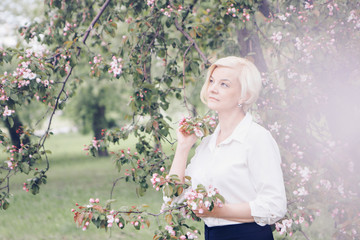 portrait of a beautiful blonde with short hair among flowers